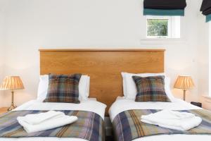 A bed or beds in a room at Elderburn Lodges 
