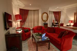 ein Wohnzimmer mit roten Stühlen und einer roten Couch in der Unterkunft Hôtel La Maison Blanche in Tunis