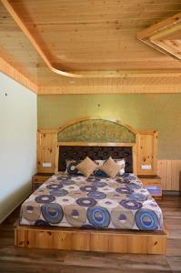 Kavya Home Stay في Chachyot: غرفة نوم بسرير كبير بسقف خشبي