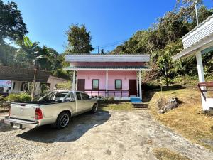 a truck parked in front of a pink house at Koh Chang Baanrimtalay in Ko Chang