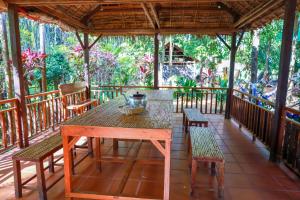 a wooden table and chairs on a porch at Community Homestay - BAKONG 