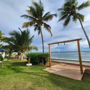 a swing on the beach with palm trees at Beachfront, Juandolio in Juan Dolio