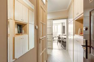 a kitchen with white cabinets and a dining room at Lovely 1 Bedroom Flat - Gazdagrét in Budapest