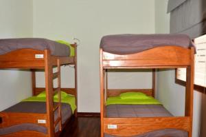 two bunk beds in a room with green sheets at Centro Turístico El Rey Condorito in Rio Claro