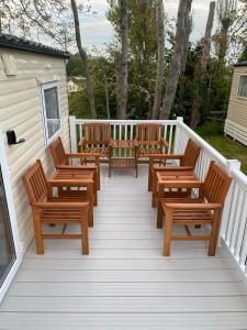 a deck with wooden chairs on a porch at Golden sands holiday park- pitch H84 in Cockwood