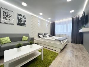 sala de estar con cama y sofá en Уютная квартира в центре, en Pavlodar