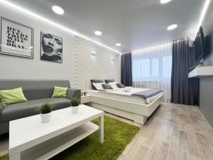 a living room with a bed and a couch at Уютная квартира в центре in Pavlodar