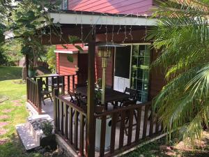 une terrasse couverte d'une maison avec une table et des chaises dans l'établissement Cabaña de las Flores. Magia en la laguna, à Santa María del Oro