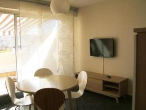 d'une salle à manger avec une table et une télévision murale. dans l'établissement Appartement Marseillan-Plage, 2 pièces, 4 personnes - FR-1-326-495, à Marseillan