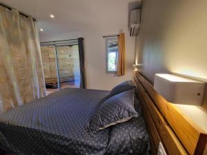 een slaapkamer met een bed met een houten hoofdeinde bij Appartement les petits Baobabs in Mamoudzou
