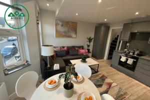 ein Wohnzimmer mit zwei Tischen und einer Couch in der Unterkunft Aisiki Apartments at Stanhope Road, North Finchley, Airconditioned Multiple 2 or 3-Bedroom, Pet Friendly Duplex Flats, King or Twin Beds with Free Wi-Fi in Finchley