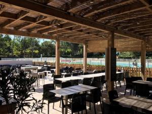 a patio with tables and chairs under a wooden pergola at Appartement Six-Fours-les-Plages, 3 pièces, 4 personnes - FR-1-316-50 in Six-Fours-les-Plages