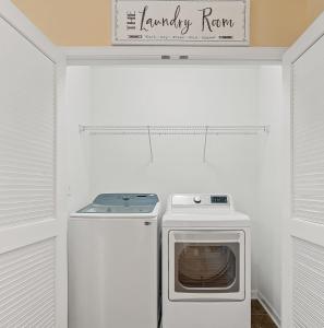 eine Waschküche mit einem Herd und einer Mikrowelle in der Unterkunft Stylish 4B 3B -King Bed- Jacuzzi in Charlotte