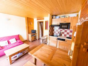 a living room with a pink couch and a kitchen at Appartement Serre Chevalier, 1 pièce, 4 personnes - FR-1-330F-119 in Serre Chevalier