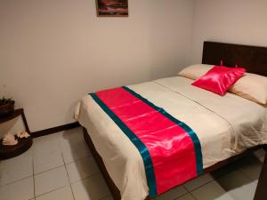a bedroom with a bed with a red pillow on it at LEHNS MOTEL in Koror