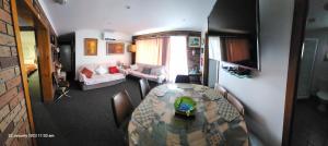 a room with a dining table and a living room at Traplins Accomodation in Lakes Entrance