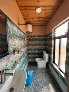 ein Bad mit einem Waschbecken und einem WC in der Unterkunft Hidden Cottage in Namchi