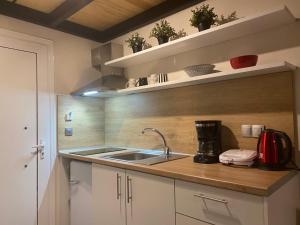 a kitchen with a sink and a coffee maker at olea resort in Iraklitsa