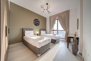 a bedroom with two beds and a chandelier at Fantastic View l 2BR l Fully Equipped in Dubai