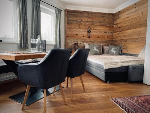 a bedroom with a bed and a desk and chairs at Apartment close to the ski area in Wald im Pinzgau
