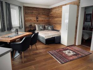 Zimmer mit einem Bett, einem Tisch und einem Kühlschrank in der Unterkunft Apartment close to the ski area in Wald im Pinzgau