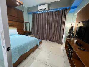 a bedroom with a bed and a christmas tree in it at Condo Unit for Rent at Pico de Loro by Raquel's Place in Nasugbu