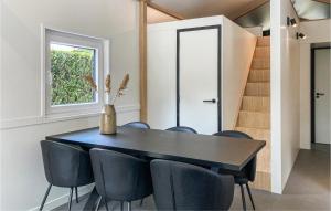 une salle à manger avec une table et des chaises noires dans l'établissement Stunning Home In Putten With Kitchen, à Putten
