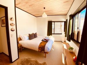 a bedroom with a bed and a window at Snowman Apartments at Madarao Mountain in Iiyama