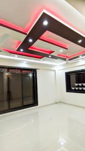 Cette chambre est dotée de lumières rouges au plafond. dans l'établissement Sukhakarta Holiday Home, à Veshvi
