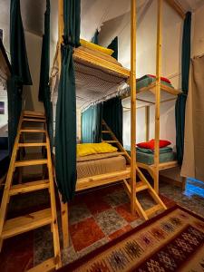 two bunk beds in a room with a ladder at Mango haus in Aqaba