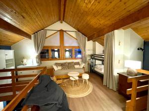 a bedroom with a bed and a table in a room at Le Chalerick - triplex rénové 6 à 8 personnes - hyper centre Valmeinier 1800 - ski aux pieds in Valmeinier