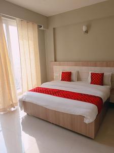 a bedroom with a large bed with red pillows at Lord Krishna Place in Vrindāvan