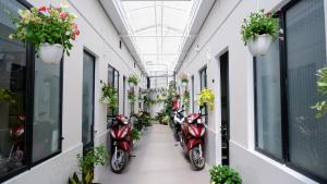 a row of scooters parked in a hallway with plants at 296 Cetete - Home in Dalat in Da Lat