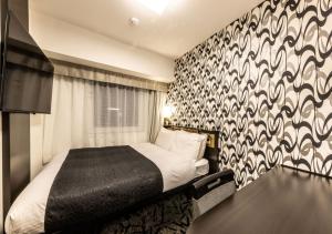 a bedroom with a bed with a black and white patterned wall at APA Hotel & Resort Osaka Umeda-eki Tower in Osaka