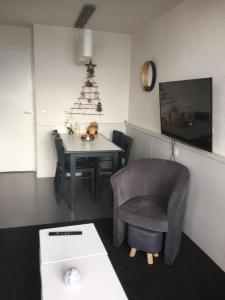 um quarto com uma cadeira e uma mesa com uma árvore de Natal em F2 résidence Antarès em Avoriaz