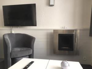 sala de estar con silla y chimenea en F2 résidence Antarès, en Avoriaz