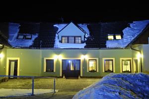 ein Haus, das nachts mit Schnee bedeckt ist in der Unterkunft Apartmány pod lípou in Horní Heřmanice
