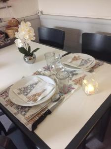 a table with plates and dishes and a candle on it at F2 résidence Antarès in Avoriaz