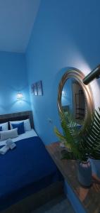 Habitación azul con cama y espejo en Chris -Nikol STUDIO, en Kallithea Halkidikis