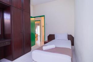 a bedroom with a bed and a dresser and a television at HIG Homestay Apartment in Kuah