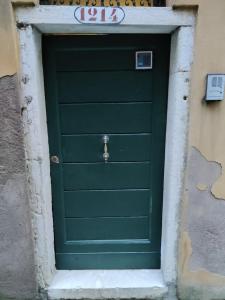 Una puerta verde en un edificio con un cartel. en alla lista, en Venecia