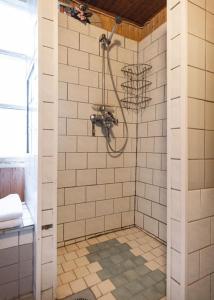 a bathroom with a shower with white tiled walls at Villa Gallela in Rovaniemi