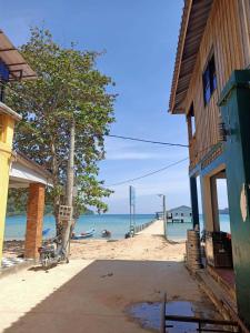 a building on the beach next to the ocean at Sam's Guesthouse M'Pai Bay in Koh Rong Sanloem