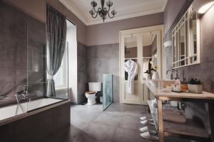 a bathroom with a tub and a sink and a toilet at Bohemian Suites Athens in Athens