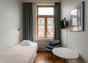 a room with a bed and a table and a window at Cochs Pensjonat in Oslo