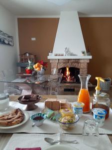 a table with food and a fireplace in a room at B&B degli Allori in Moggiona