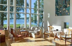 uma sala de estar cheia de mobiliário e janelas grandes em Cozy Home In Domsj With Kitchen em Domsjö