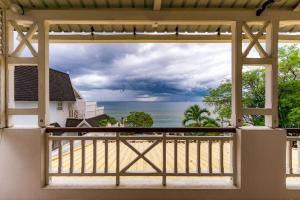 a view of the ocean from the balcony of a house at Beachfront Tamarin Villa in Tamarin