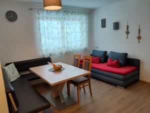 a living room with a table and a couch at Apart Isabella in Brandberg