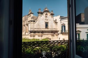 a window view of an old building from a balcony at Sui Lecci in Matera